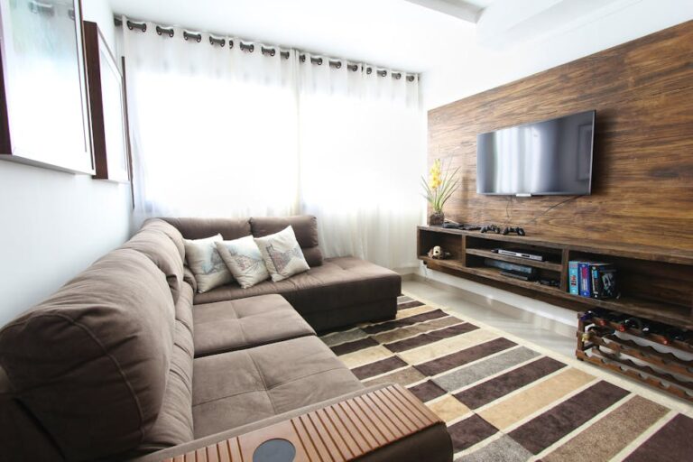 Modern living room with a brown sofa, decorative pillows, and a wall-mounted television — typical home streaming setup